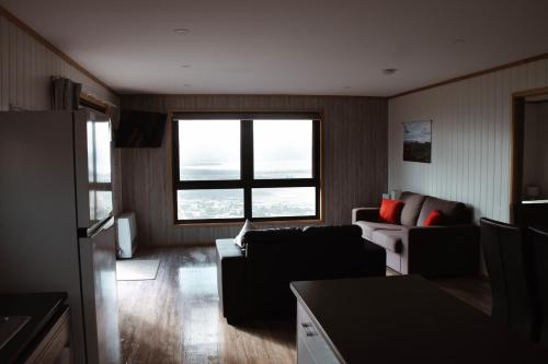 a living room with a couch and a window at Mount Rumney Escapes - 3 Seaview Wombat House in Mount Rumney