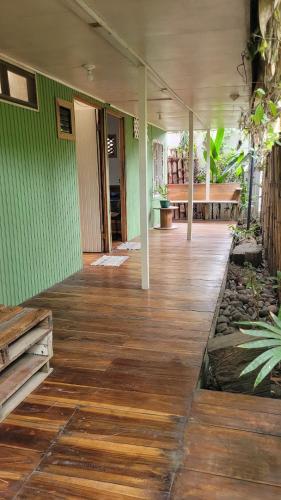 a porch of a house with a wooden floor at Roots Family in Puerto Viejo