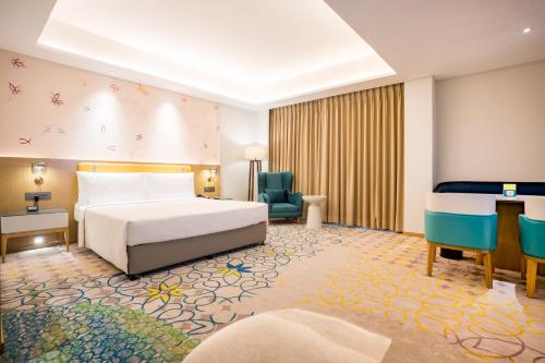 a hotel room with a bed and a chair at Holiday Inn Lucknow Airport by IHG in Lucknow