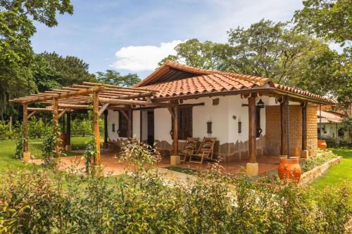 a small house with a wooden pergola at Refugio Ecoturístico Villa Clarita in Estación El Salto