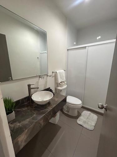 a bathroom with a sink and a toilet and a mirror at Apartamento en Zona Playa Cerritos in Mazatlán