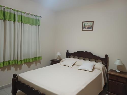 a bedroom with a large bed with green curtains at Alquiler Casa Anvers 548 para 8 personas, 4 habitaciones, con Wi-Fi y Parrilla, a 400 metros del mar! Septiembre, Octubre, Noviembre, Diciembre y Temporada Verano 2026 in Ostende