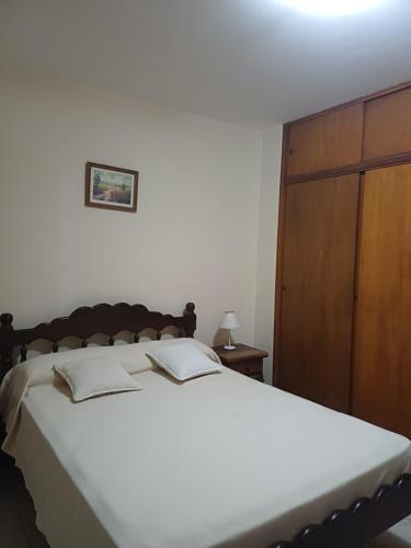 a bedroom with a large bed and a wooden cabinet at Alquiler Casa Anvers 548 para 8 personas, 4 habitaciones, con Wi-Fi y Parrilla, a 400 metros del mar! Septiembre, Octubre, Noviembre, Diciembre y Temporada Verano 2026 in Ostende