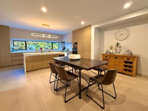 a kitchen and dining room with a table and chairs at Elegant New Luxury Retreat in Remuera in Auckland
