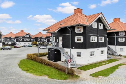 a large black and white house with a parking lot at FY382-Bogense-Vestre-Engvej-104-1-tv in Bogense