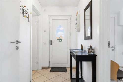 a hallway with a table and a white door at FY382-Bogense-Vestre-Engvej-104-1-tv in Bogense