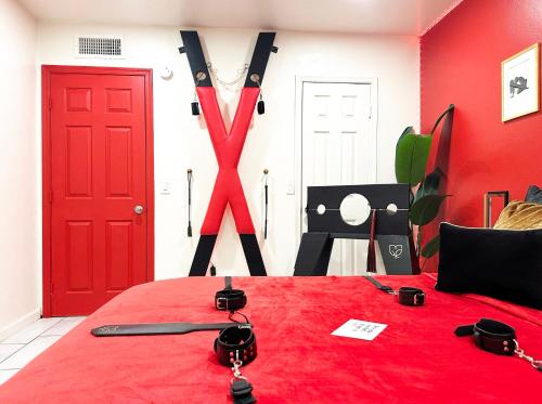 a bedroom with a red bed with a baseball bat on it at Luxury Lovers Escape Hot Tub & Fantasy Suite in Tucson