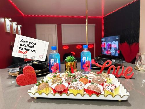 a table with a plate of cupcakes and a sign at Luxury Lovers Escape Hot Tub & Fantasy Suite in Tucson
