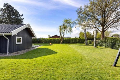 a large yard with a small shed and a house at FY386-Hesselager-Stentoften-22 in Hesselager