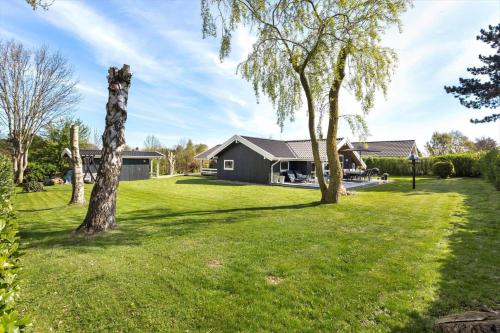 a yard with two trees and a house at FY386-Hesselager-Stentoften-22 in Hesselager
