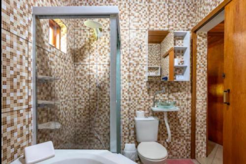 a bathroom with a shower with a toilet and a sink at Chalé Recanto da Paz in Itu
