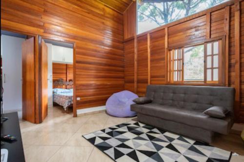 a living room with a couch and a bedroom at Chalé Recanto da Paz in Itu