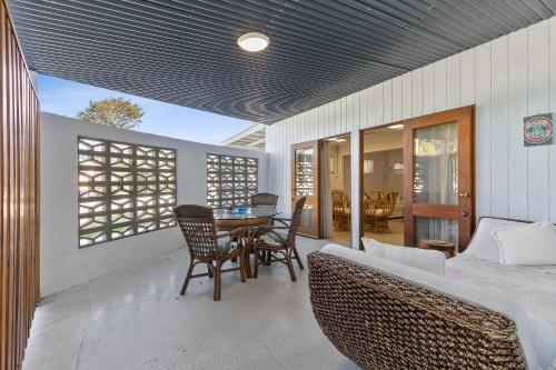 a room with a bed and a table and chairs at Funky Lil Shack - by the jetty in Bongaree
