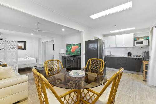 a kitchen and dining room with a table and chairs at Funky Lil Shack - by the jetty in Bongaree