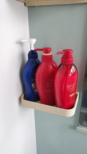 three red and blue bottles sitting on a shelf at 箱根と熱海の中間駅徒歩10分海徒歩3分のリビエラマナヅル in Wada