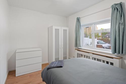 Harrow on the Hillにある6 Beds, 3 Baths, Harrow, Wembley, London 20mins Train to Wembley Stadium, London Maryleboneのベッドと窓のある寝室