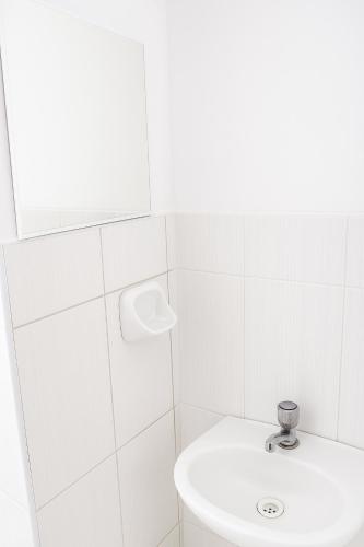 a white bathroom with a sink and a mirror at Nery Lodging in Huaraz