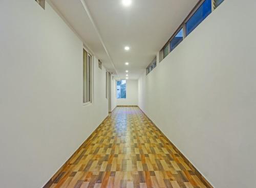 an empty hallway with wood floors and windows at Super Townhouse Che Sigma in Hyderabad