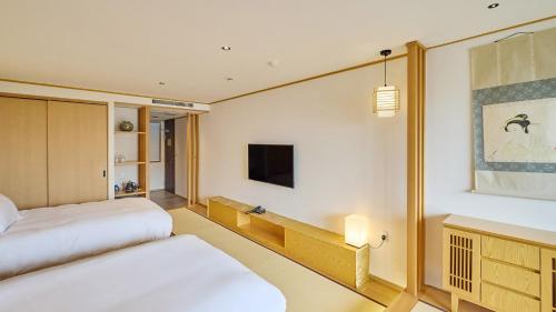 una camera d'albergo con due letti e una televisione di Kumonoue Fuji Hotel - Vacation STAY 13703v a Oishi