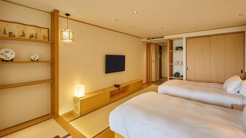 Una habitación de hotel con dos camas y un televisor. en Kumonoue Fuji Hotel - Vacation STAY 13714v, en Oishi