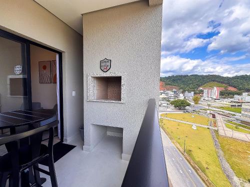 a room with a balcony with a view of a city at Apto com 1 quarto e sacada com churrasqueira in Brusque