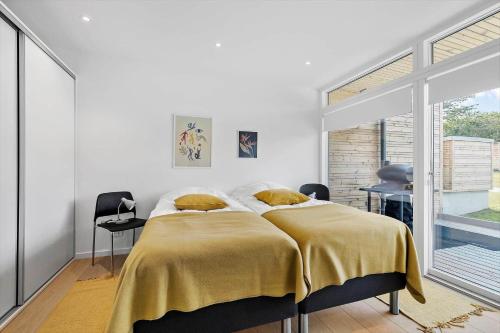 a bedroom with a bed with a yellow blanket on it at 5607-Svaneke-Mollebakken-8-P in Svaneke