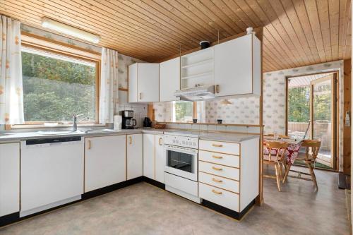 a kitchen with white cabinets and a table and chairs at 2715-Nexo-Munkegardsskoven-32 in Neksø