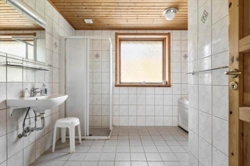 a white bathroom with a sink and a shower at 2715-Nexo-Munkegardsskoven-32 in Neksø
