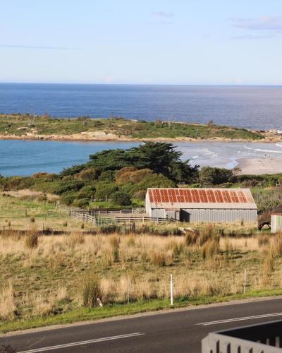 a building on the side of a road near the ocean at Travellers Rest Bicheno in Bicheno
