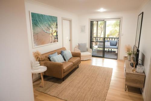 a living room with a couch and a table at Melo Beach Escape - Luxury Gnarabup beach house in Gnarabup