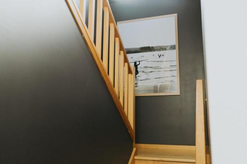 a staircase in a house with a picture on the wall at Melo Beach Escape - Luxury Gnarabup beach house in Gnarabup