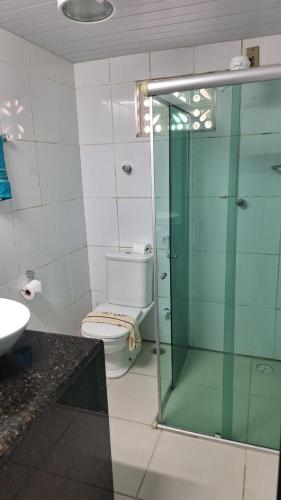 a bathroom with a toilet and a glass shower at Casa Porto in Porto De Galinhas