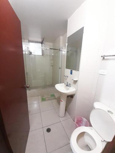 a bathroom with a toilet and a sink and a shower at Hotel Central in Latacunga