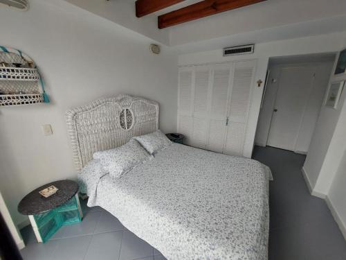 a small bedroom with a bed and a table at Apartaamento en San Andres frente al mar con balcon in San Andrés