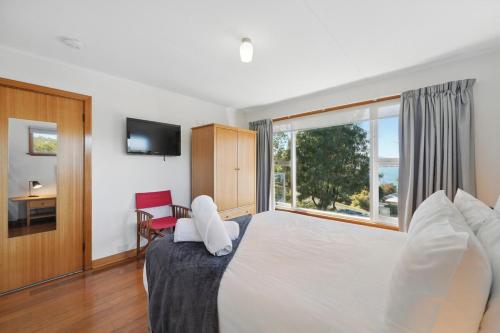 a bedroom with a large bed with a large window at Coningham Beach House - 3 Bedrooms in Coningham
