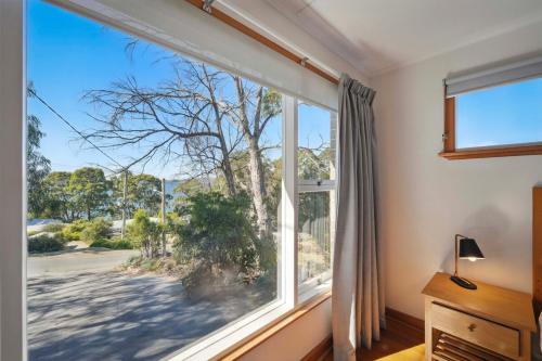 a window in a room with a view of a tree at Coningham Beach House - 3 Bedrooms in Coningham