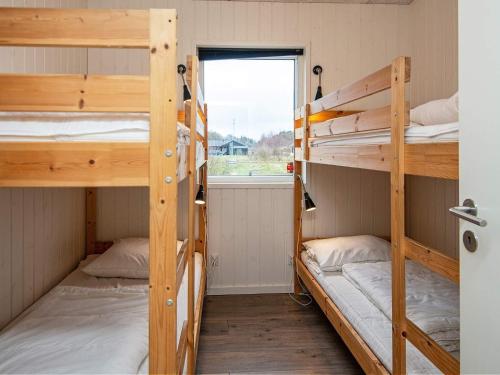 two bunk beds in a room with a window at 14 person holiday home in Glesborg in Glesborg