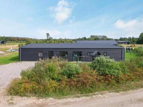 a black house on the side of a road at 14 person holiday home in Glesborg in Glesborg