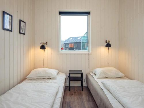 two beds in a room with a window at 14 person holiday home in Glesborg in Glesborg