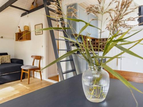a glass vase sitting on a table with a plant in it at 4 person holiday home in Karrebæksminde-By Traum in Karrebæksminde