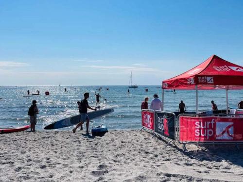 a group of people on a beach with people in the water at 4 person holiday home in Karrebæksminde-By Traum in Karrebæksminde