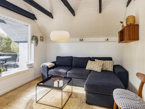a living room with a blue couch and a table at 4 person holiday home in Karrebæksminde-By Traum in Karrebæksminde