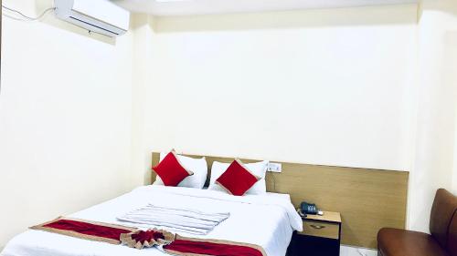 a hotel room with a bed with red pillows at Hotel Kavya International in Bharatpur
