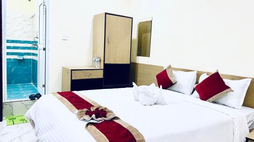 a bedroom with two beds with white and red pillows at Hotel Kavya International in Bharatpur