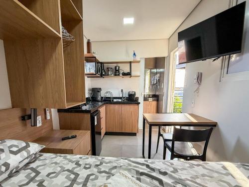 a small kitchen with a table and a dining room at Flat Studio Alto Padrão em Patos de Minas in Patos de Minas