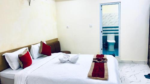 a bedroom with a bed with red and white pillows at Hotel Kavya International in Bharatpur
