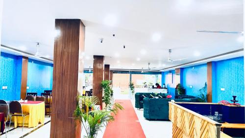 a lobby with blue walls and tables and chairs at Hotel Kavya International in Bharatpur