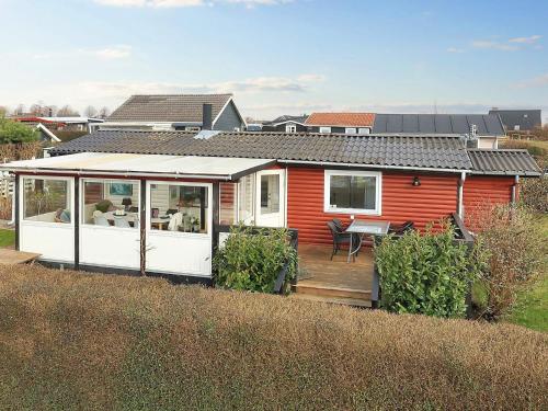 a small red and white house with a deck at 5 person holiday home in Karrebæksminde in Karrebæksminde