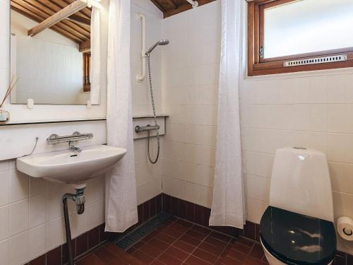 a bathroom with a sink and a toilet and a window at Holiday home in a park in Gilleleje in Gilleleje