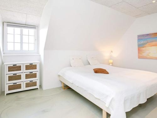 a white bedroom with a bed and a window at 20 person holiday home in Ulfborg in Ulfborg